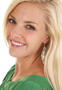 A woman with a green top and a big smile.